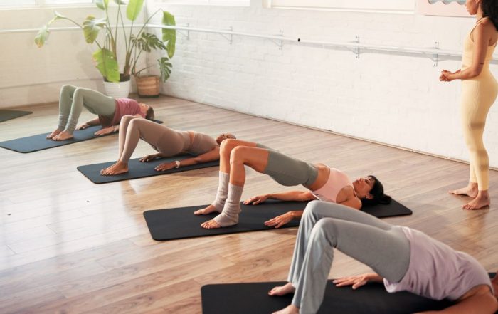 Group class of women doing core exercise on exercise mat